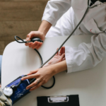 Healthcare professional measuring a patient’s blood pressure during a routine medical assessment