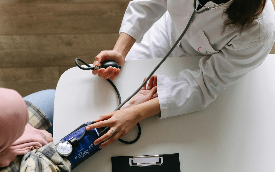 Healthcare professional measuring a patient’s blood pressure during a routine medical assessment