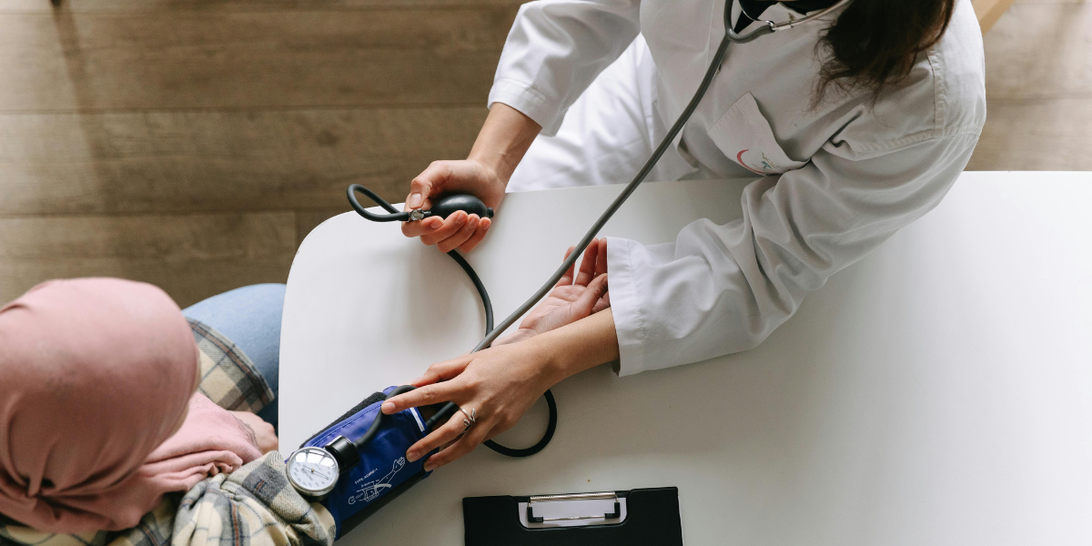 Healthcare professional measuring a patient’s blood pressure during a routine medical assessment