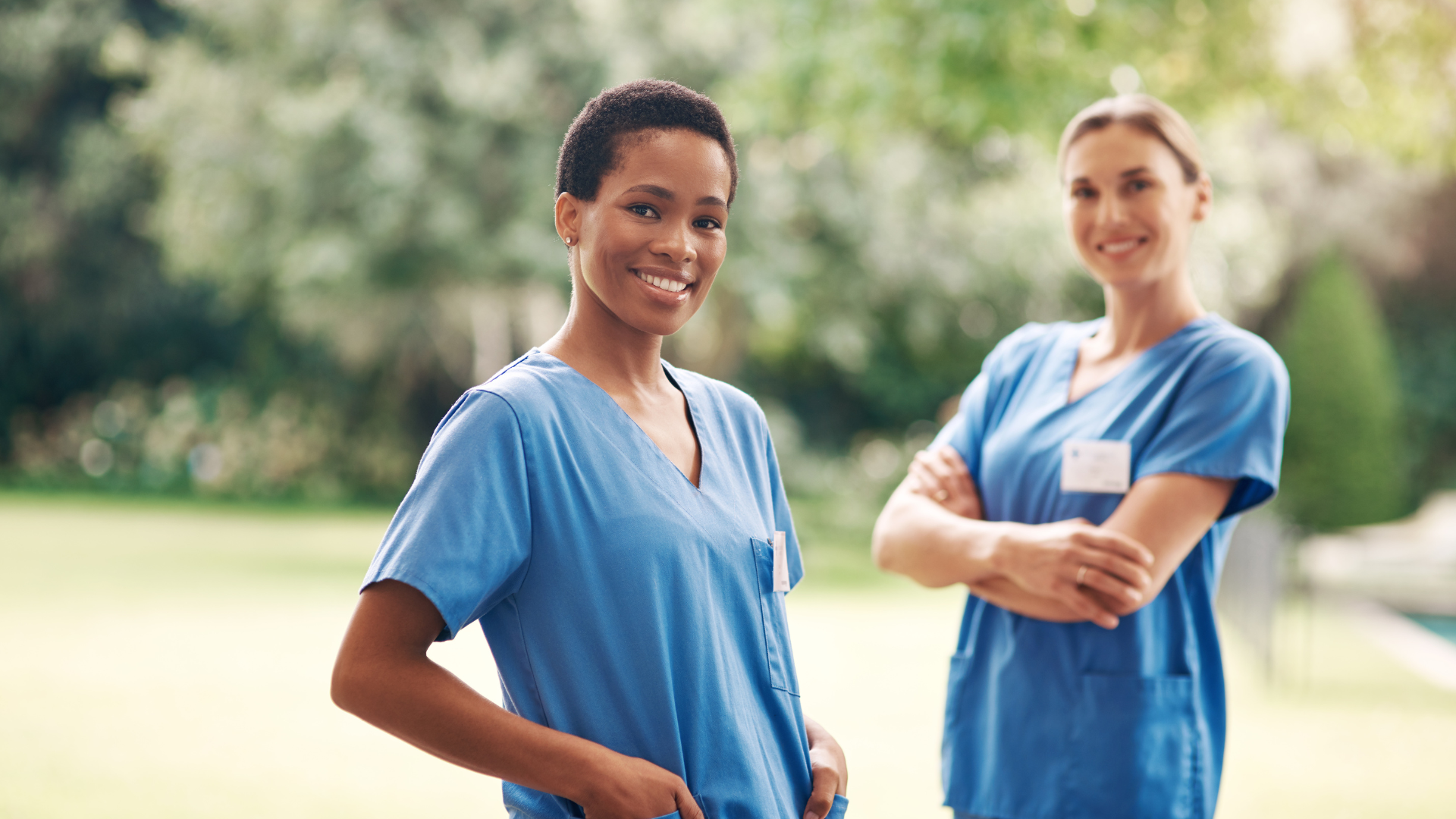 Bilingual Nurses wearing hospital scrubs smiling