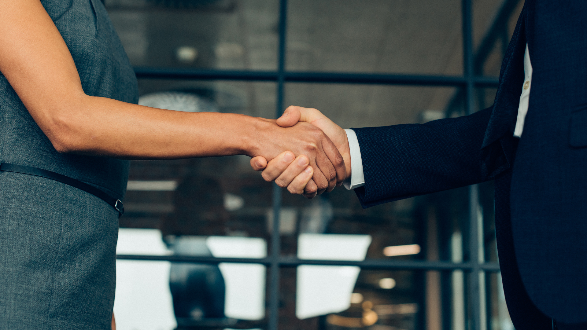 Healthcare facility administrator and staffing agency representative shaking hands over contract