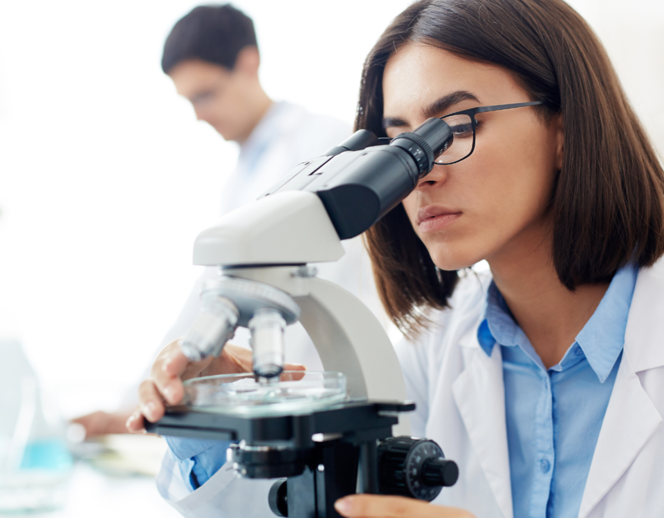 Medical lab technologist using microscope for sample analysis representing healthcare workforce shortage