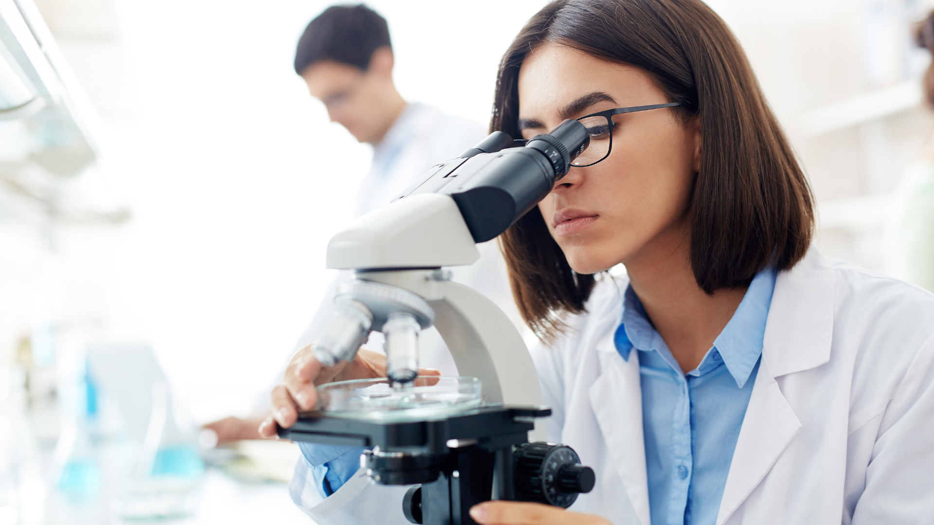 Medical lab technologist using microscope for sample analysis representing healthcare workforce shortage