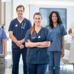 Group of allied health professionals including physiotherapist, occupational therapist, medical laboratory technologist, and speech-language pathologist working together in a healthcare setting, representing diverse allied health professions in Canada.