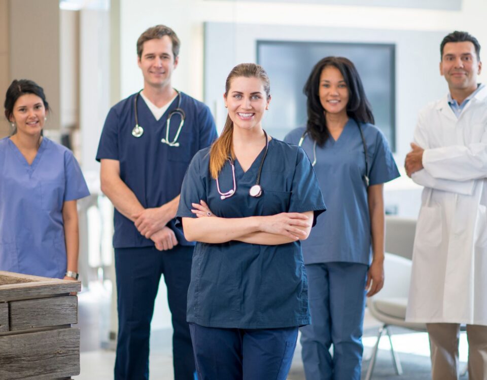 Group of allied health professionals including physiotherapist, occupational therapist, medical laboratory technologist, and speech-language pathologist working together in a healthcare setting, representing diverse allied health professions in Canada.