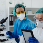 Two medical laboratory technicians working together at lab equipment, representing Canada's medical technologist shortage across healthcare facilities.